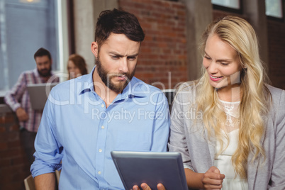 Man and woman looking towards digital tablet