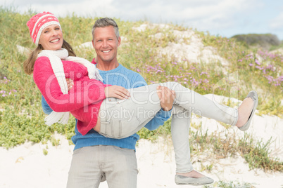 Smiling happy man carrying a woman