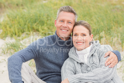 Smiling couple sitting on the sand