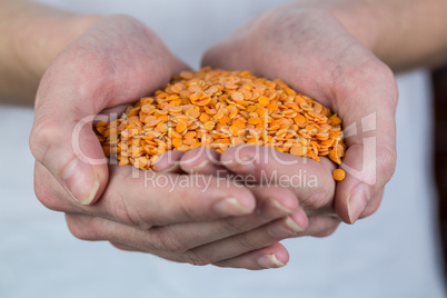 Woman showing handful of red lentils