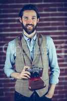 Portrait of smiling hipster with camera