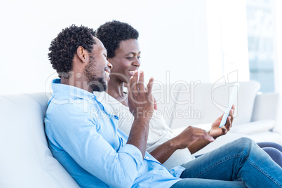 Couple smiling and looking at digital tablet