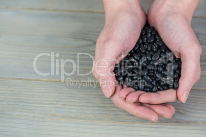 Woman showing handful of black beans