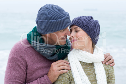 Smiling happy couple both wearing scarfs and hats