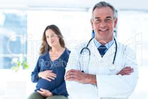 Portrait of smiling doctor with pregnant woman at clinic