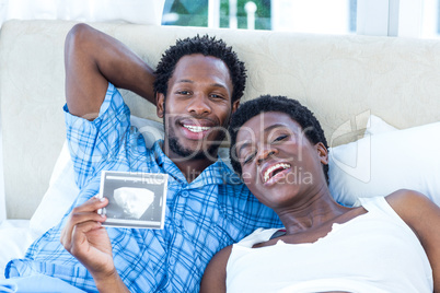 Portrait of happy woman holding ultrasound scan