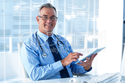 Portrait of male doctor with digital tablet in hospital