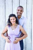 Portrait of smiling pregnant with husband touching belly