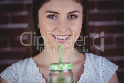 Pretty woman sipping on green juice
