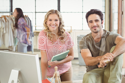 Portrait of happy fashion designers in office