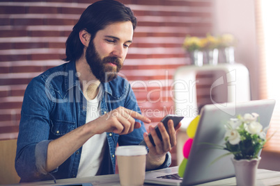 Confident creative businessman using smartphone