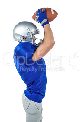 Side view of American football player catching ball