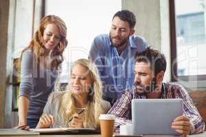 Business people working while discussing in office