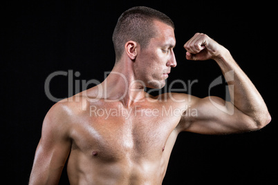 Serious shirtless athlete flexing muscles