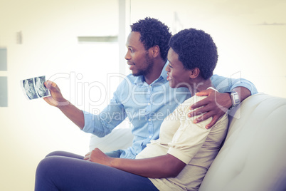 Husband showing photo to pregnant wife