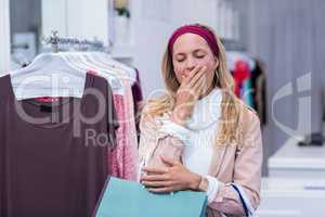 Tired woman with shopping bags yawning