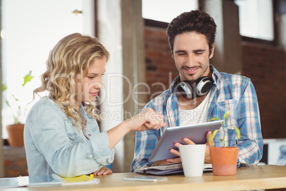 Happy business people looking at digital tablet in office