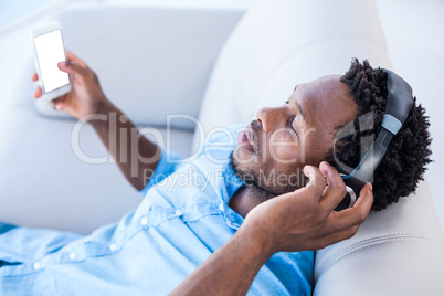 Man enjoying music while relaxing on sofa