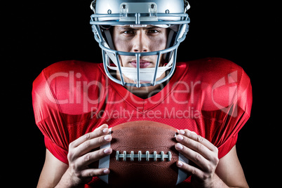 Close-up portrait of confident American football player holding