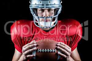 Close-up portrait of confident American football player holding