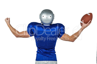 American football player flexing muscles while holding ball