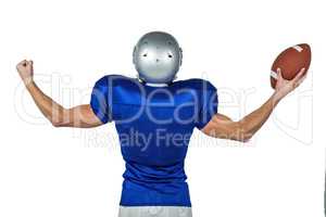 American football player flexing muscles while holding ball