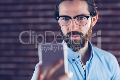 Confident hipster holding cellphone