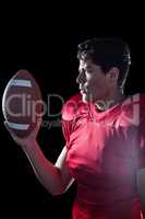 Confident sportsman holding American football