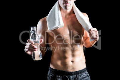 Fit shirtless man with towel on neck holding water bottle