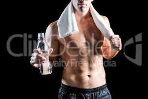 Fit shirtless man with towel on neck holding water bottle