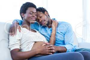 Pregnant woman with husband relaxing at home