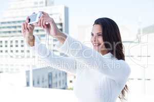 Pretty brunette taking selfie with camera