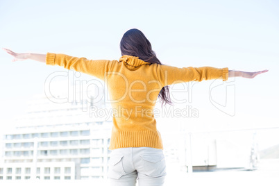 Woman looking camera with arms raised on