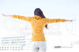 Woman looking camera with arms raised on
