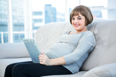 Portrait of smiling pregnant woman using digital tablet Portrait of smiling pregnant woman using digital tablet