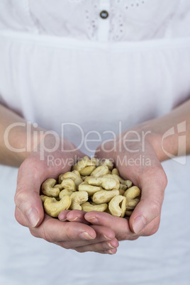 Woman showing handful of cashews