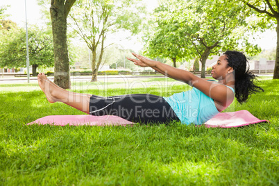 Young woman doing pilates on mat