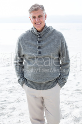 Smiling man standing in the sand