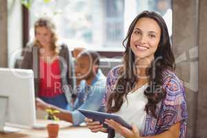 Portrait of smiling businesswoman holding digital tablet