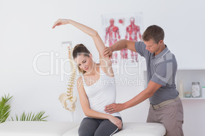 Doctor stretching a young woman arm