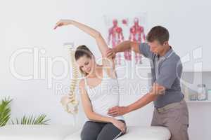 Doctor stretching a young woman arm