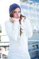 Cold brunette in warm clothes looking at camera