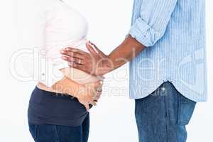 Man touching belly against white background
