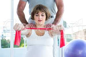 Pregnant woman exercising with resistance band