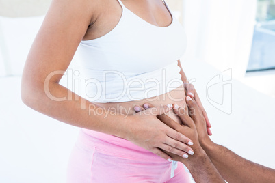 Pregnant wife with husband touching belly