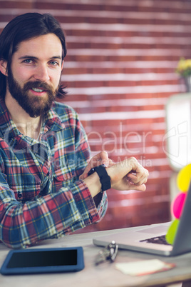 Portrait of smiling creative businessman checking time