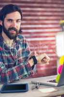 Portrait of smiling creative businessman checking time