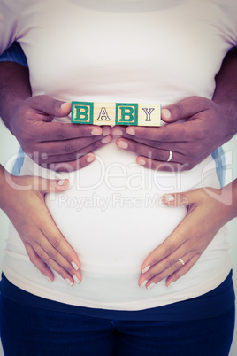 Midsection of man with wife holding baby text
