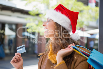 Smiling woman with santa hat and shopping bags