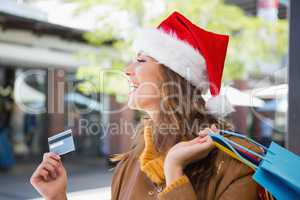 Smiling woman with santa hat and shopping bags